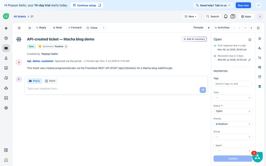 Ticket #21 open in the Freshdesk UI, created moments earlier via a real POST /api/v2/tickets API call. The ticket body states it was created programmatically via the REST API for a Macha blog walkthrough; reported 'via the portal' by Api. demo. customer.